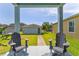 Inviting back porch with black Adirondack chairs facing the backyard and guest house at 6111 Hadley Commons Dr, Riverview, FL 33578