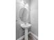 Bathroom featuring a pedestal sink with a round mirror, updated fixture, and gray walls at 6111 Hadley Commons Dr, Riverview, FL 33578
