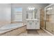 Bright bathroom featuring a soaking tub, glass enclosed shower, and a white vanity with generous storage at 6111 Hadley Commons Dr, Riverview, FL 33578