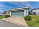 Detached garage with a light blue garage door, manicured shrubs, and large driveway at 6111 Hadley Commons Dr, Riverview, FL 33578
