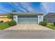 Detached two car garage with blue garage door framed by green landscaping at 6111 Hadley Commons Dr, Riverview, FL 33578