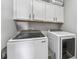 A functional laundry room featuring front-load washer and dryer plus upper cabinets at 6111 Hadley Commons Dr, Riverview, FL 33578