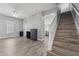 Open-concept living space with light gray walls, wood floors, and a staircase at 6111 Hadley Commons Dr, Riverview, FL 33578