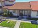 Charming townhome featuring a red tile roof, brick accents, and a cozy front patio at 7360 Ulmerton Rd # 29B, Largo, FL 33771