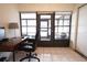 Office with dark wood desk, chair, lamp and large windows leading to a screened room at 7360 Ulmerton Rd # 29B, Largo, FL 33771