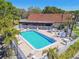 Community pool with lounge chairs and palm trees surrounded by a white picket fence at 7360 Ulmerton Rd # 29B, Largo, FL 33771