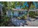 Charming single-story home with mature landscaping and a brick walkway leading to the front door at 810 Lantana Ave, Clearwater Beach, FL 33767