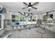 Spacious living room with a ceiling fan, light grey floors, and large windows overlooking the pool and backyard at 810 Lantana Ave, Clearwater Beach, FL 33767
