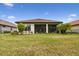 A serene backyard with manicured lawn, established landscaping, and a screened-in patio at 8725 Sorano Villa Dr, Tampa, FL 33647