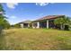 Large backyard showcasing well-maintained lawn, landscaping, and screened-in lanai at 8725 Sorano Villa Dr, Tampa, FL 33647