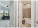 View of a bathroom with a tub, gray tiled shower, and the corner of an office is visible through the doorway at 8725 Sorano Villa Dr, Tampa, FL 33647