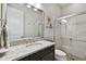 Modern bathroom with sleek vanity, granite countertops, and glass-enclosed shower featuring white subway tiles at 8725 Sorano Villa Dr, Tampa, FL 33647