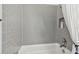 A well-lit bathroom with gray subway tile surrounding a tub and shower with a shower curtain, providing a modern feel at 8725 Sorano Villa Dr, Tampa, FL 33647