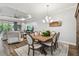 Open concept dining room with a view to the living room, hard wood floors and modern lighting at 8725 Sorano Villa Dr, Tampa, FL 33647