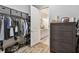 Well-organized walk-in closet leading to a bathroom, with a dresser visible at 8725 Sorano Villa Dr, Tampa, FL 33647