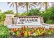 A welcome sign with lush landscaping and colorful flowers at 8725 Sorano Villa Dr, Tampa, FL 33647