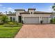 Charming home featuring a tile roof, brick driveway, and a well-manicured lawn at 8725 Sorano Villa Dr, Tampa, FL 33647