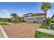 Charming home featuring a tile roof, brick driveway, and a well-manicured lawn at 8725 Sorano Villa Dr, Tampa, FL 33647