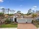 Stunning front exterior of home with a three car garage, brick driveway, and lush landscaping at 8725 Sorano Villa Dr, Tampa, FL 33647