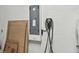 Garage interior featuring a ChargePoint electric vehicle charging station, electrical panel, and storage for household items at 8725 Sorano Villa Dr, Tampa, FL 33647