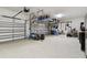 Spacious three car garage with epoxy flooring, overhead racks, and ample storage space for vehicles and equipment at 8725 Sorano Villa Dr, Tampa, FL 33647