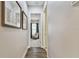 Hallway with wood floors and framed art leading to a sitting area with blue drapes at 8725 Sorano Villa Dr, Tampa, FL 33647