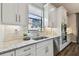 Well-lit kitchen boasts white cabinets, granite countertops, stainless steel appliances, and a decorative stained glass window detail at 8725 Sorano Villa Dr, Tampa, FL 33647
