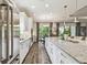 Open-concept kitchen featuring stainless steel appliances, granite countertops, hardwood floors, and seamless connection to the living area at 8725 Sorano Villa Dr, Tampa, FL 33647