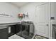 Efficient laundry room featuring modern washer and dryer, granite countertop, and storage shelves at 8725 Sorano Villa Dr, Tampa, FL 33647