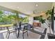 Covered patio with a dining area, seating area, TV, and views of the lush backyard at 8725 Sorano Villa Dr, Tampa, FL 33647