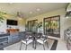 Covered patio featuring a dining area, seating area, TV, and outdoor kitchen, offering a versatile outdoor living space at 8725 Sorano Villa Dr, Tampa, FL 33647
