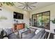 Stylish screened patio with comfortable seating, TV, and a tranquil view of the surrounding landscape at 8725 Sorano Villa Dr, Tampa, FL 33647