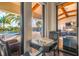 View from interior showing chess table and a glimpse of the community pool area through large windows at 8725 Sorano Villa Dr, Tampa, FL 33647