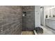 Modern shower featuring stylish wood-look tile, pebble floor, and convenient built-in niche at 8725 Sorano Villa Dr, Tampa, FL 33647