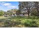 Backyard with a large tree and green grass, showing the exterior of the home at 9825 Casey Dr, New Port Richey, FL 34654