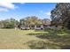 Home exterior with large yard, mature trees, and a white truck parked in the driveway at 9825 Casey Dr, New Port Richey, FL 34654