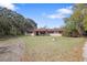 Ranch-style home with a well-manicured lawn and mature trees creating a serene and private setting at 9825 Casey Dr, New Port Richey, FL 34654
