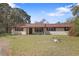 Inviting single-story home with a cozy front porch and natural landscaping, offering a tranquil and relaxing ambiance at 9825 Casey Dr, New Port Richey, FL 34654