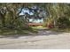 A home with a classic ranch style, set back with a long driveway, fence and vibrant bushes at 9825 Casey Dr, New Port Richey, FL 34654