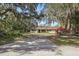 Charming ranch-style home featuring a spacious driveway, mature trees, and a well-maintained front yard at 9825 Casey Dr, New Port Richey, FL 34654