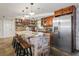 The kitchen features a stone island, stone accents, stainless steel refrigerator, and wooden cabinets at 9825 Casey Dr, New Port Richey, FL 34654