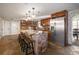 The kitchen features a stone island, stone accents, stainless steel refrigerator, and wooden cabinets at 9825 Casey Dr, New Port Richey, FL 34654