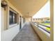 A spacious balcony featuring views of the tennis court and lush landscaping on a bright, sunny day at 103 1St E St # 115, Tierra Verde, FL 33715