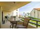 Relaxing balcony with seating overlooking the beach and palm trees at 103 1St E St # 115, Tierra Verde, FL 33715