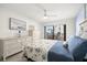 Bright bedroom with a cozy bed, coastal accents, and sliding door access to a private balcony at 103 1St E St # 115, Tierra Verde, FL 33715