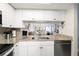 Open kitchen design with granite countertops, bright white cabinets, and views into the living space at 103 1St E St # 115, Tierra Verde, FL 33715