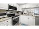 Contemporary kitchen featuring stainless steel appliances, granite countertops, and a pass-through window at 103 1St E St # 115, Tierra Verde, FL 33715
