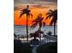 Sunset view from the community pool overlooking the bay with beautiful palm trees and tiki hut at 103 1St E St # 115, Tierra Verde, FL 33715