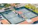 Aerial view of well-maintained tennis courts surrounded by lush greenery at 103 1St E St # 115, Tierra Verde, FL 33715