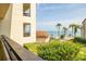 Balcony view of the pool, palm trees, and waterfront, creating a serene tropical oasis at 103 1St E St # 115, Tierra Verde, FL 33715